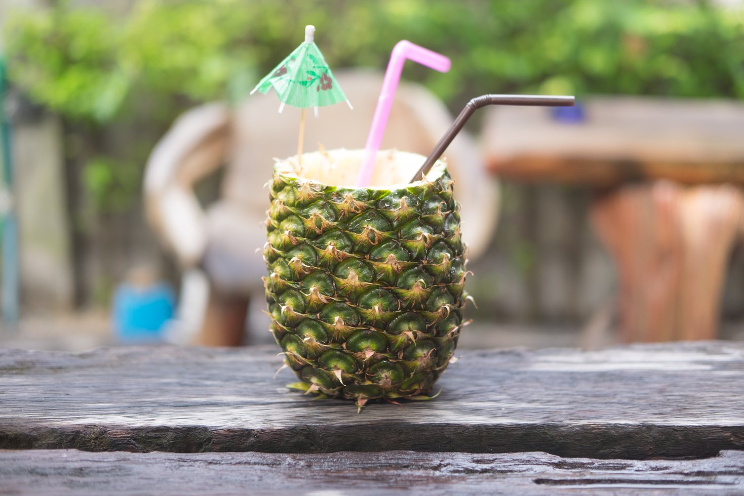 Pineapple smoothie in pineapple bowl on table